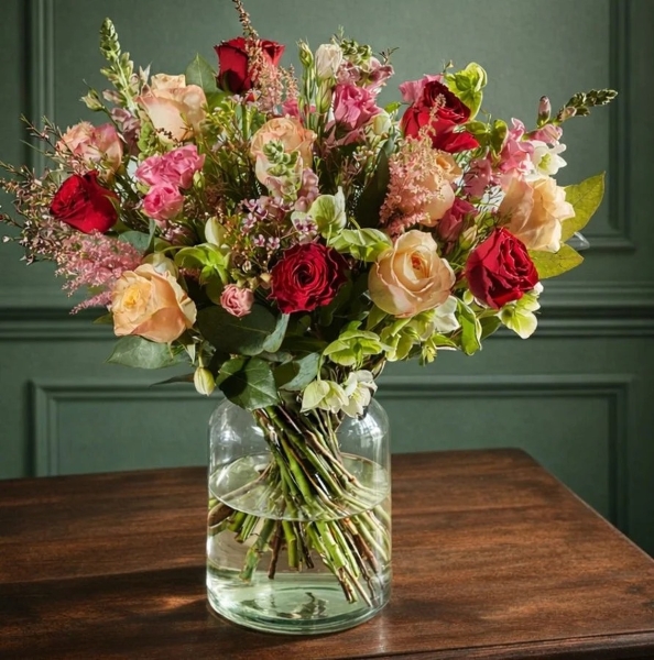 Bright hand tied bouquet of bold seasonal flowers in vivid pinks, oranges and reds, made fresh each morning