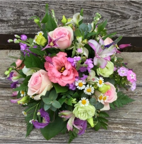 Florist choice funeral posy of fresh seasonal flowers in soft colours