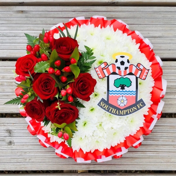 Football club funeral posy in team colours with a club crest centre
