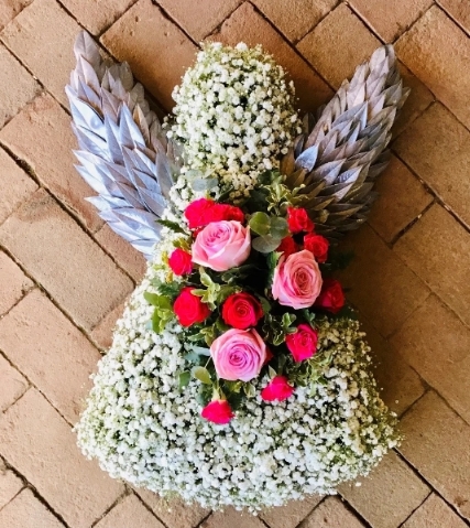 Angel shaped funeral tribute massed in white flowers