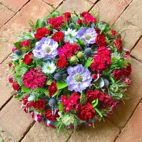 Florist choice posy pad of mixed seasonal flowers set in floral foam