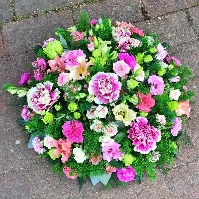 Posy pad of pink and green seasonal flowers set in floral foam